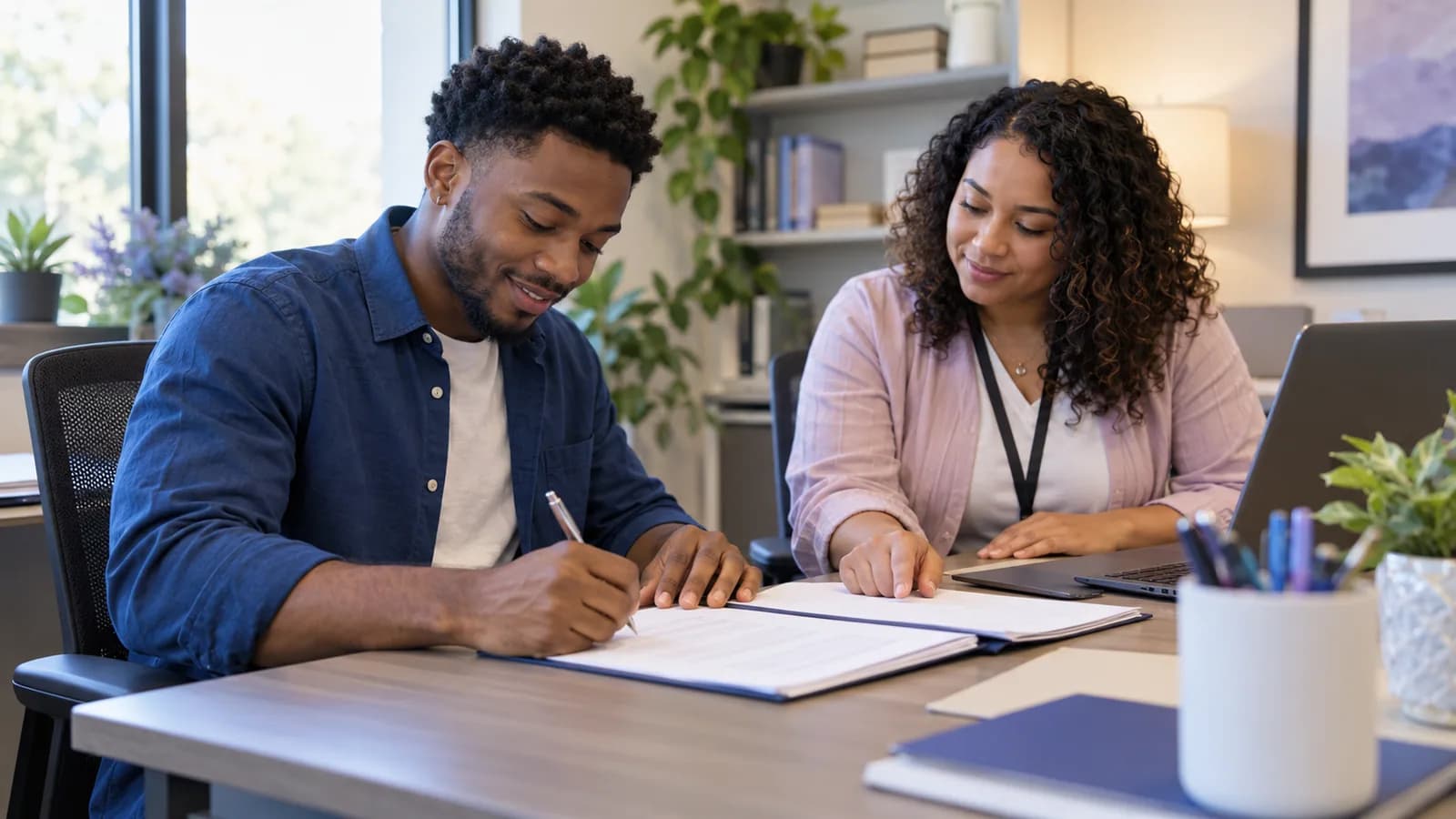 A new employee completing onboarding paperwork with a colleague.